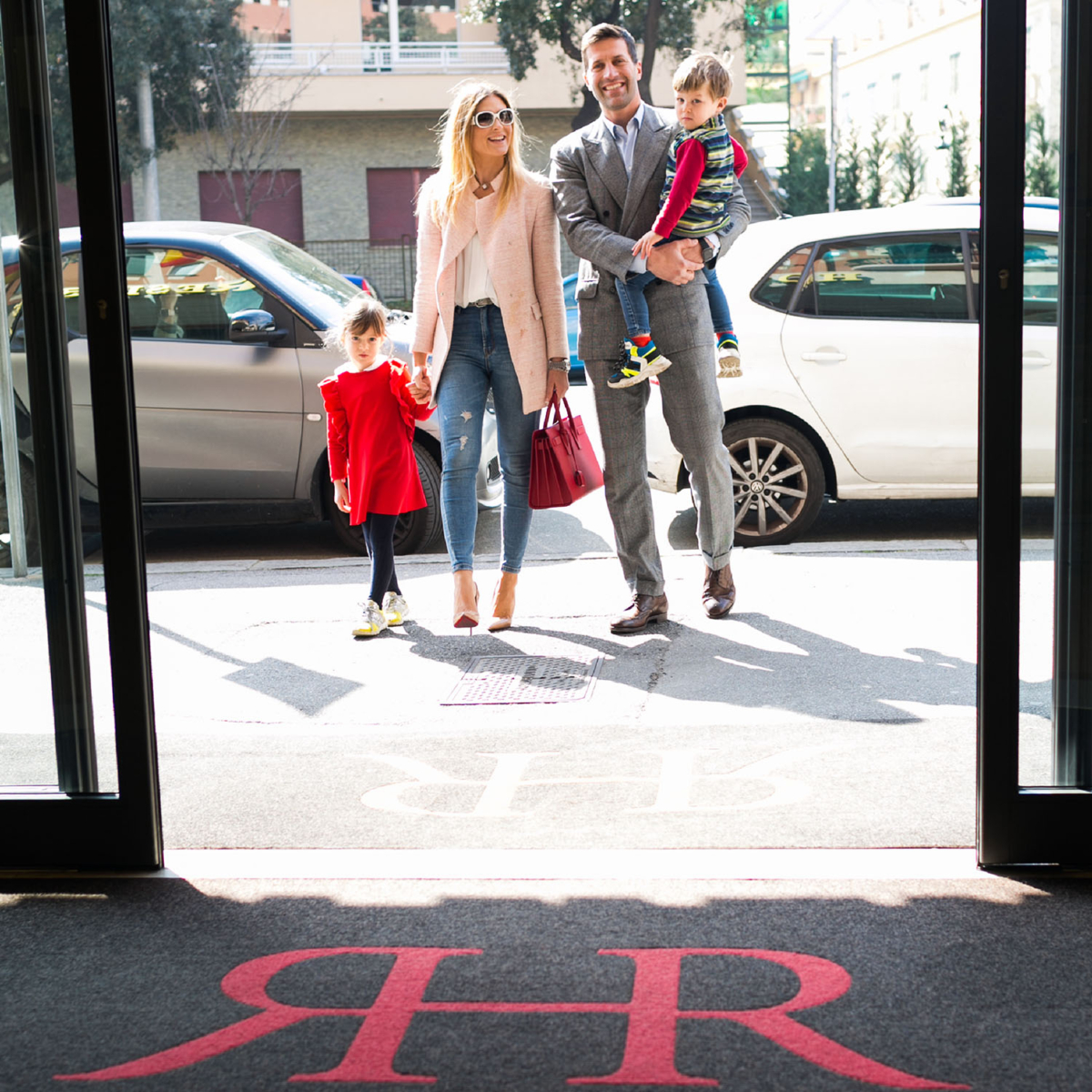 famiglia-ingresso Famiglia di turisti con bambini all'ingresso del Rex